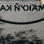 a close up of a sign with a person walking in the background
